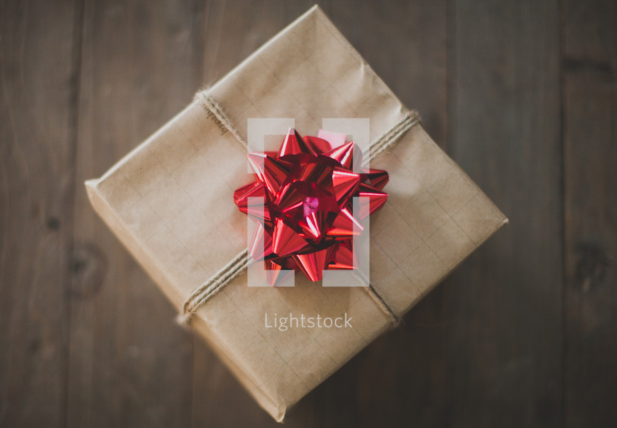 gift wrapped in brown paper and a red bow 