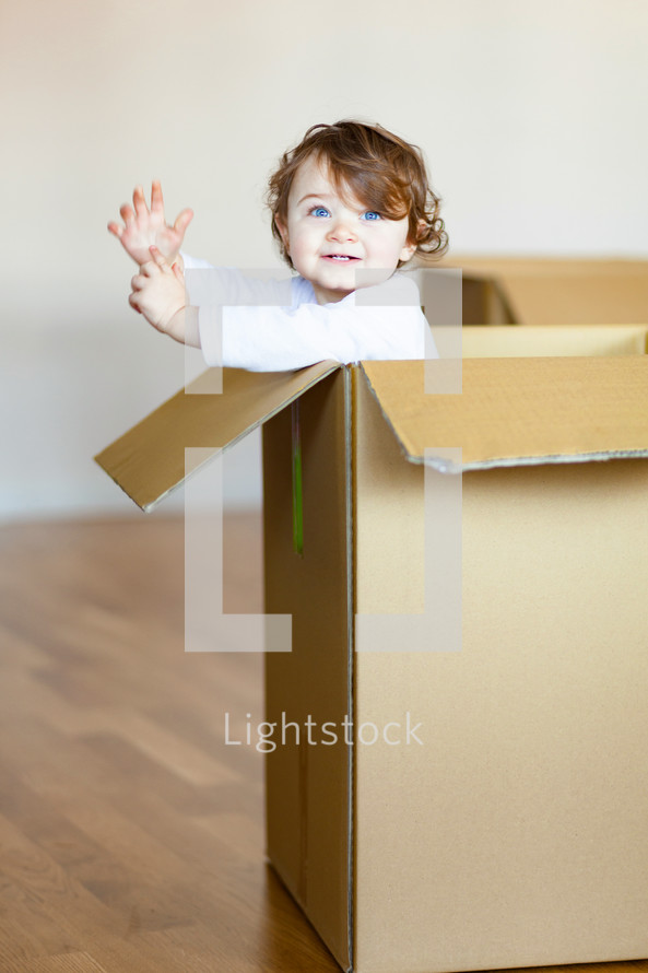 toddler girl in a cardboard box 