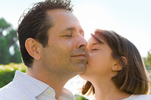 little girl kissing her dad on the cheek
