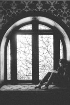 A woman sitting in a window seat. 