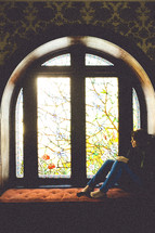 woman sitting in a window