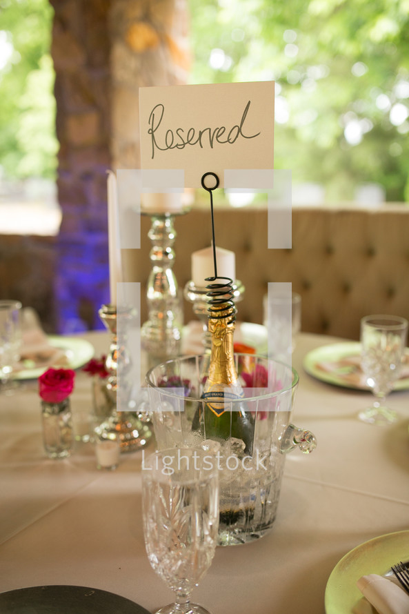 Reserved sign on a champagne bottle at a wedding reception table 