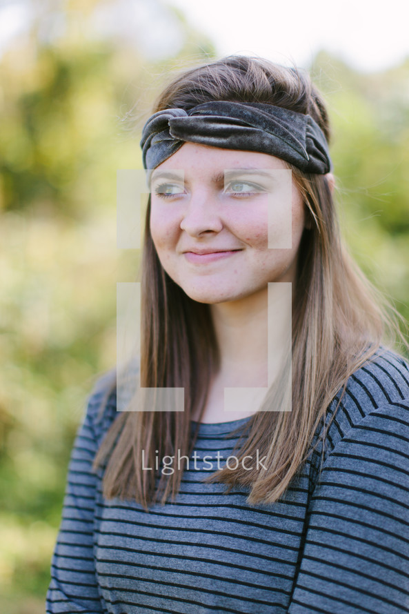 head shot of a teen girl standing outdoors 