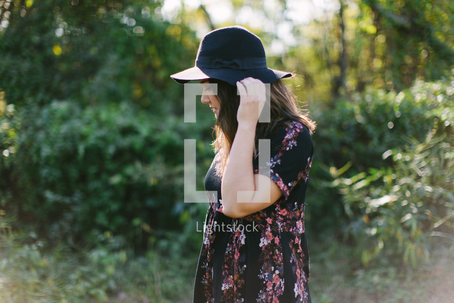 teen girl in a hat standing outdoors 