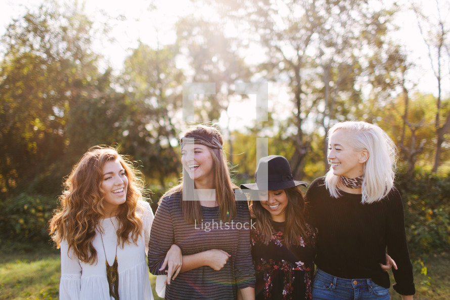 teen girls standing outdoors laughing 