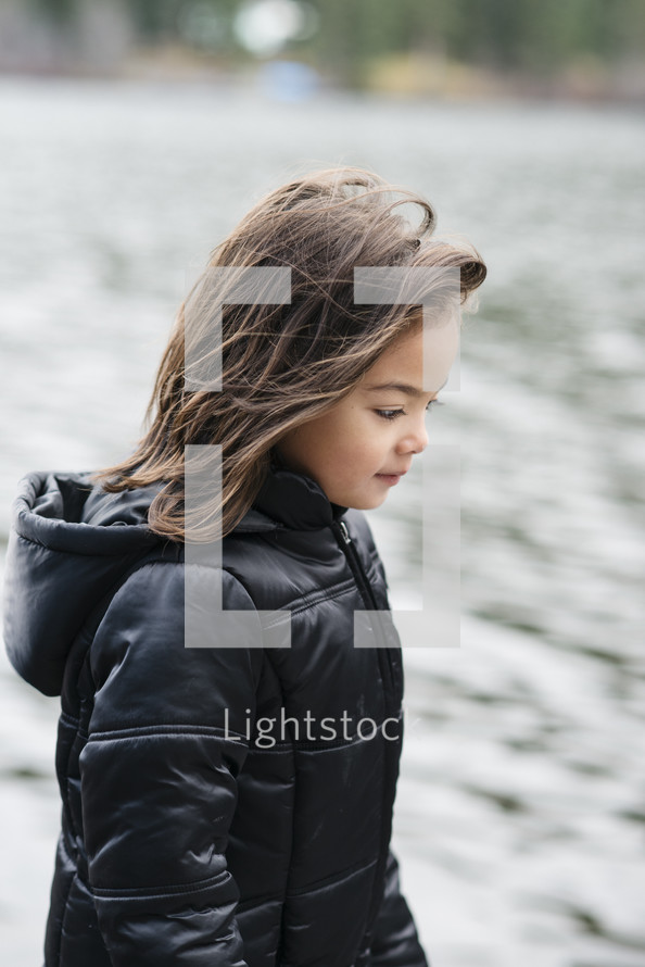 girl child walking outdoors in a winter coat 
