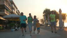 Happy family finishing evening run on resort