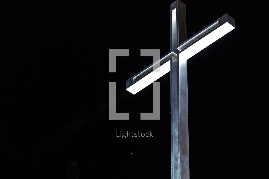A metal cross against a black background.