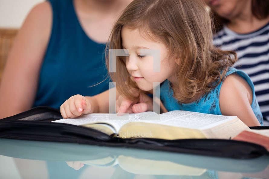 a family reading a Bible with a child 