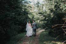 bride and groom walking on a path 