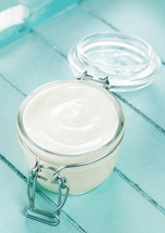 Jar of yogurt on a light blue wooden tray