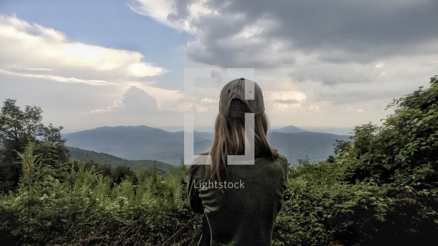 woman looking out at clouds over the Blue Ridge Mountains 