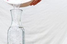 pouring water in a glass jar 