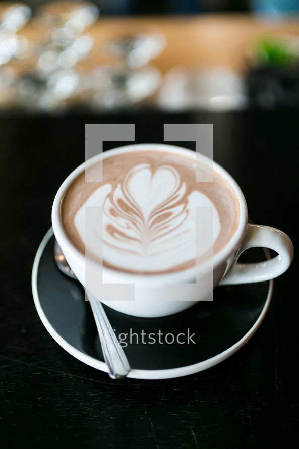 a heart shape in creamer in a coffee cup 