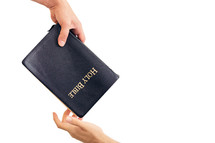 Hand Giving Someone A Bible