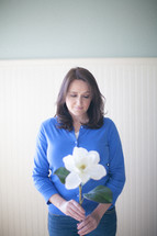woman holding a magnolia flower in prayer