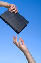 Hand giving Bible