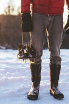 a man holding ice skates 