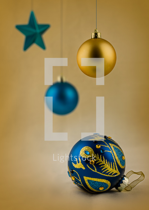 Blue and gold Christmas ornaments on a gold background.