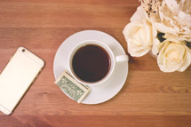 tip, iPhone, wood table, coffee, cup, saucer, flowers, cash, money, cellphone, phone