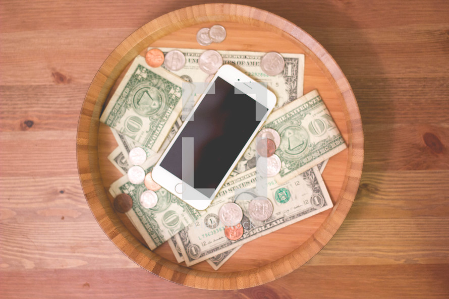 Iphone and money in a wood bowl 