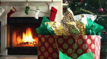 Christmas presents by a tree and fireplace