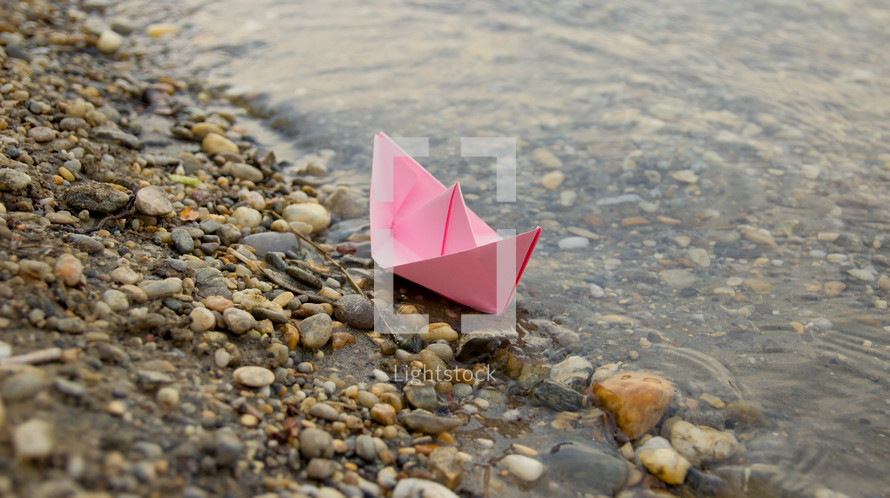 paper boat on a shore 