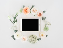 wreath of flowers around an iPad 