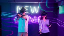 A man and a woman play a virtual reality game with goggles.