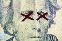 red X over the eyes of Andrew Jackson on $20