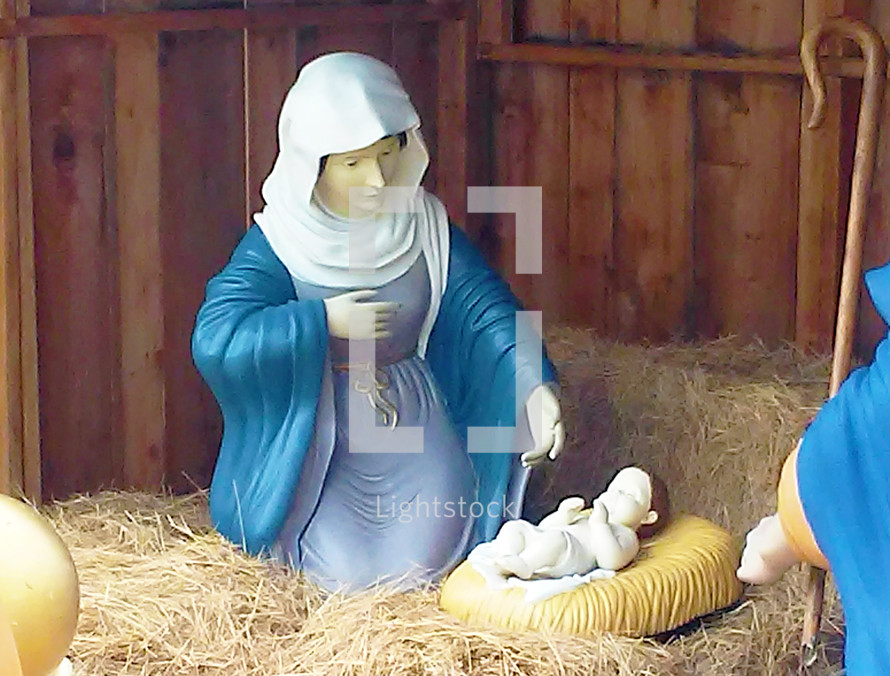 Mary and Jesus in outdoor nativity scene on hay