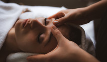 face of young woman having facial massage at spa.