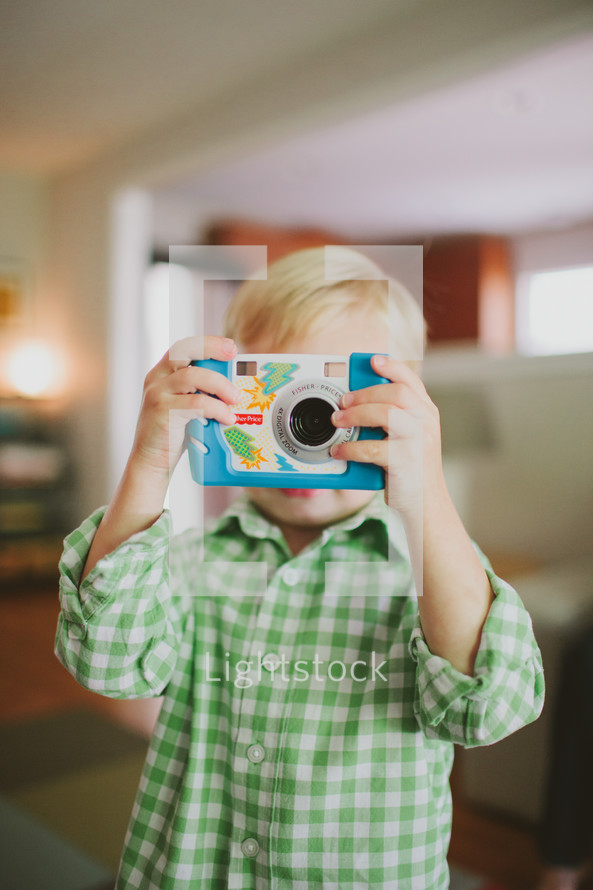 child taking a picture with a camera 