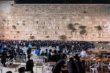 men sitting at the Western wall in Jerusalem 