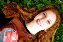 Happy woman lying in clover