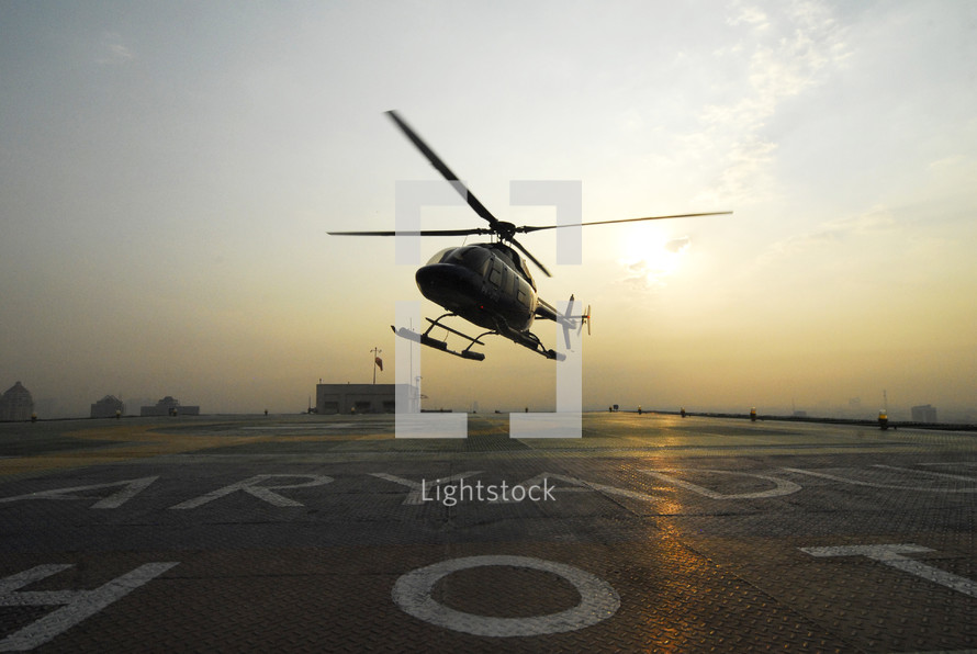 Helicopter landing on rooftop at Sunset. 