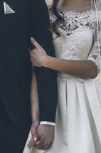 a bride and groom holding hands 