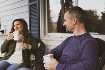 husband and wife having coffee on the front porch 