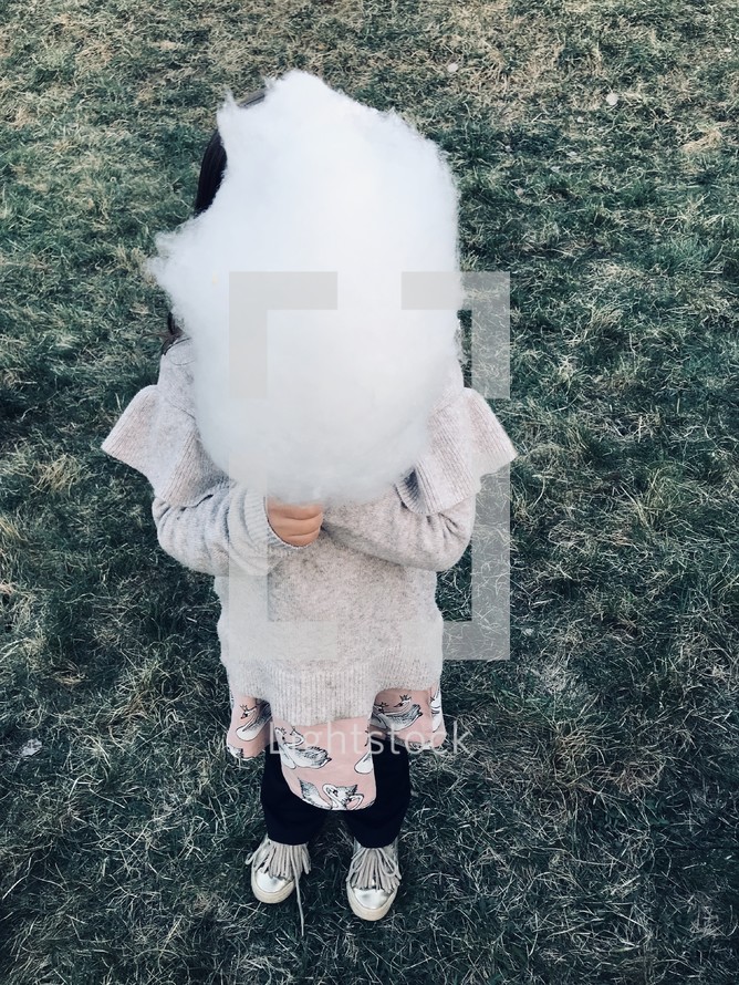little girl holding cotton candy 