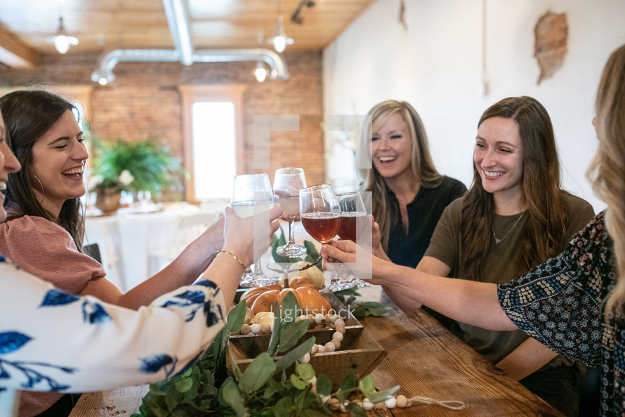 smiling women toasting wine glasses 