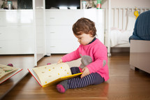 toddler girl reading a book 