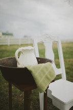 washing basin and pitcher and a white chair for a wedding feet washing ceremony
