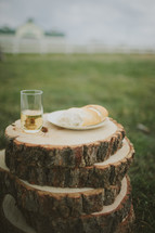 Bread and wine on a table of stacked log pieces.