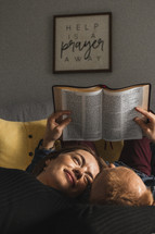 Couple reading Bible on bed
