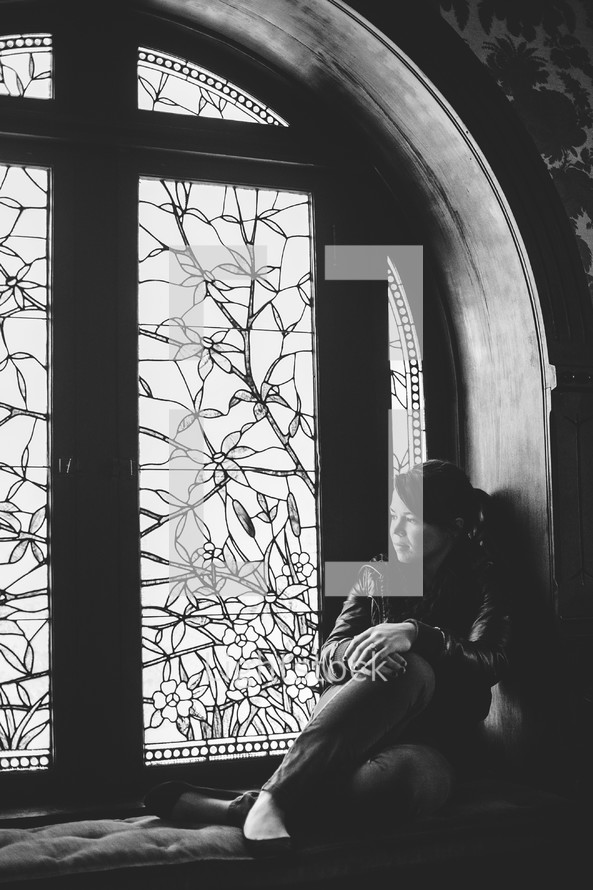 woman sitting in a window 