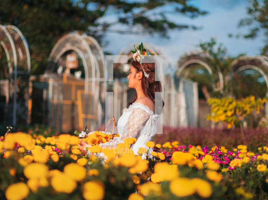 a teen girl standing in a flower garden 
