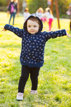 toddler girl playing outdoors at a park 
