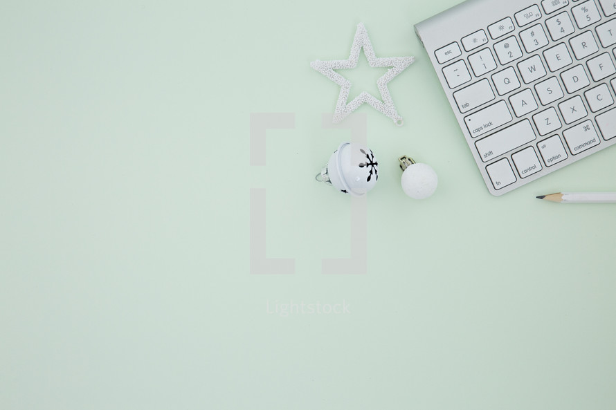 computer keyboard and white ornaments on mint green 