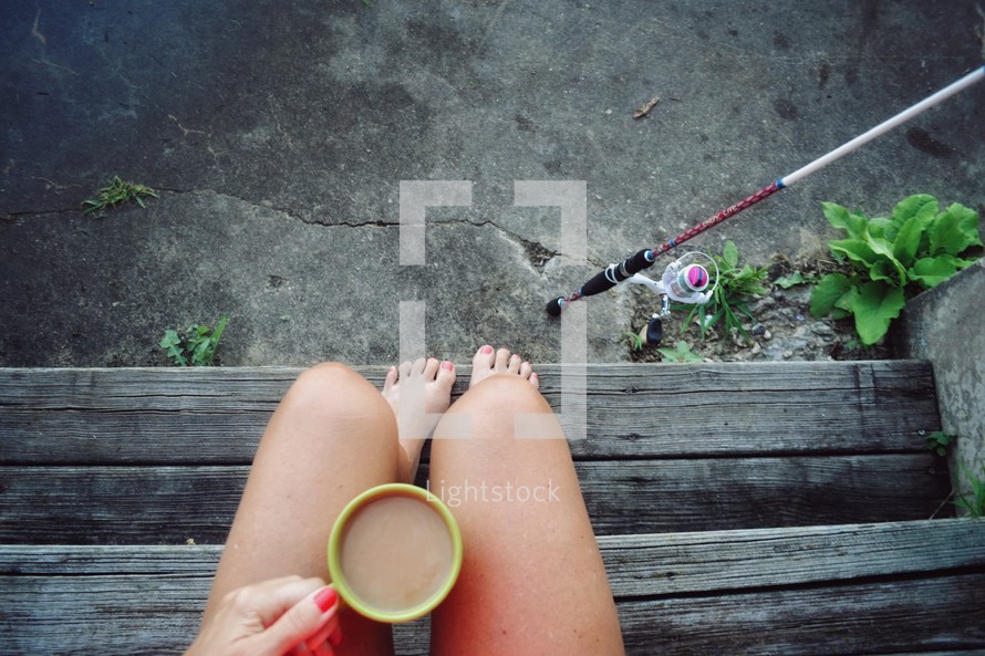 woman with a coffee cup and fishing pole 