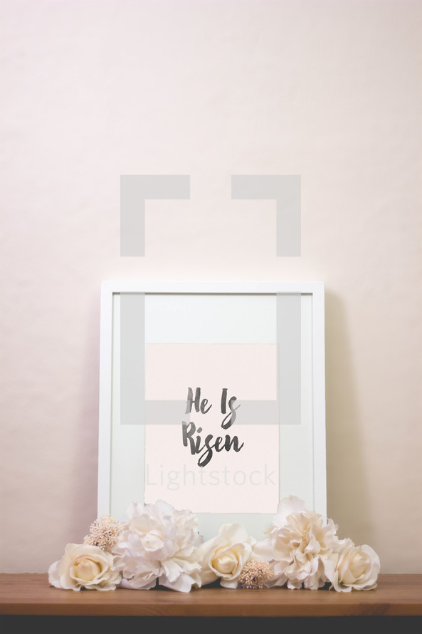 words he is risen in a frame with flowers 